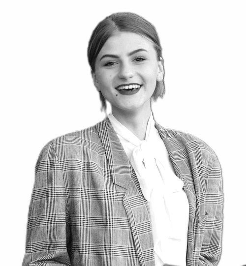 A professional woman in a suit and tie smiling.