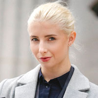 Image of a woman with blonde hair in a stylish jacket.